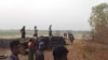 FILE - Men stand over a funeral pyre in Tar Taing village, as they prepare to cremate bodies of those found dead in the nearby village of Nyaung Yin, Myinmu township and in Tar Taing village, Sagaing township, central Myanmar on March 2, 2023. 