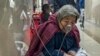 ARCHIVO – Una paciente de la tercera edad recibe una inyección por goteo intravenoso mientras usa un respirador en el corredor de una sala de emergencia en Beijing, el 5 de enero de 2023.
