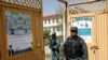 Afghan policemen stand guard at a gate of a voter registration center for the upcoming parliamentary and district council elections in Kabul, Afghanistan, April 23, 2018.