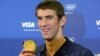 U.S. swimmer Michael Phelps poses with his gold medal for the 4x100m medley relay during a news conference with his sponsors at the London 2012 Olympic Games, August 5, 2012. 