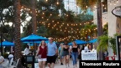 Personas sin máscaras caminan a pesar del rebrote de COVID-19 en San Petersburgo, Florida, el 7 de agosto de 2021.