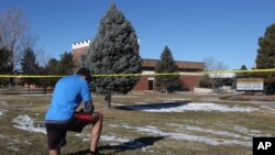 Un vecino se detuvo a orar frente a la escuela Arapahoe, el sábado.