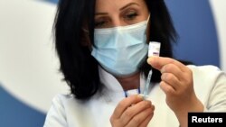 Medicinska radnica na Kosovu priprema dozu vakcine AstraZeneca.