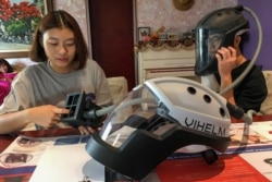 Los estudiantes Tran Nguyen Khanh An, de 14 años, y Do Trong Minh Duc, de 16, trabajan en casa con un prototipo de casco llamado Vihelm, que diseñaron para proteger a enfermeras y médicos de contraer la enfermedad por coronavirus (COVID-19).