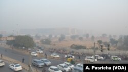 Delhi is blanketed in a grey haze of pollution on Christmas Eve as morning commuters pass by, Dec. 24, 2018.