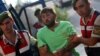 FILE - Turkish gendarmeries escort one of the 11 fugitive commandos, who were involved in a failed coup attempt, at the police headquarters in Mugla, Turkey, Aug. 1, 2016. 