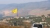 FILE - A U.N. peacekeepers (UNIFIL) vehicle drives past a Hezbollah flag in the southern Lebanese village of Khiam, near the border with Israel, July 28, 2020.