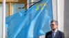 Міністр закордонних справ України Дмитро Кулеба перед прапором кримськотатарського народу з чорною стрічкою під час церемонії вшанування пам’яті жертв масової депортації кримських татар у 1944 році. Київ, Україна, 17 травня, 2024. REUTERS
