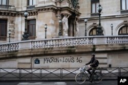 Un hombre en bicicleta sostiene una bandera francesa cerca del Arco del Triunfo en París durante una manifestación el sábado 1 de diciembre de 2018.