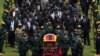 The casket of former Zimbabwean president Robert Mugabe, covered by the national flag and followed by family and dignitaries, arrives for a state funeral at the National Sports Stadium, in the capital Harare, Zimbabwe, Sept. 14, 2019.