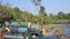 A man leaps onto a truck as it forges a creek in a rural part of Burma's Kachin state, February 26, 2012.