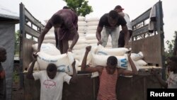Volunteers unload maize meal supplied by the United Nations Food Program at the Lovua refugee camp in Angola, Sept. 13, 2017. More than 6,000 Congolese have fled to Zambia in the last month.