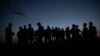 FILE - Refugees who fled the conflict in the Ethiopia's Tigray gather after the sun sets in Hamdayet, eastern Sudan, near the border with Ethiopia, March 23, 2021.