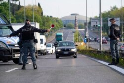 Oficiales de policía detienen automóviles en un punto de control en una calle de Roma el 13 de abril de 2020.