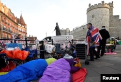 Royal fans are seen sleeping on the pavement having spent the night outside of Windsor Castle, the location for the forthcoming wedding of Britain's Prince Harry and his fiancee Meghan Markle, in Windsor, Britain, May 18, 2018.
