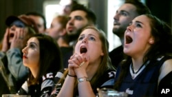 Aficionadas de los Patriotas muestran su sufrimiento mientras ven el juego en un bar de Boston.