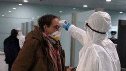 Un oficial de salud norcoreano realiza una prueba en una de las personas en el aeropuerto de Pyongyang.