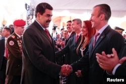 El presidente de Venezuela Nicolas Maduro, saluda con su nuevo vicepresidente Tareck El Aissami durante una reunión ministerial en Caracas.