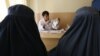 FILE - An Afghan mental health doctor, center, talks with patients in the Mental Health and Drug Addicts' Hospital in Kabul, Afghanistan, July 17, 2016.