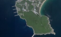 FILE - This August 18, 2020, image courtesy of Planet Labs Inc. reportedly shows a Chinese submarine (center, bottom) entering an underground base on Hainan Island on the South China Sea.
