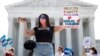 Terrisa Bukovinac, founder of Pro-Life San Francisco, holds a model of a fetus as she and other anti-abortion protesters wait outside the Supreme Court for a decision, June 29, 2020. 