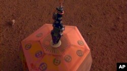Esta foto facilitada por el Laboratorio de Propulsión a Chorro de la NASA muestra un sismógrafo colocado en suelo de Marte por la sonda InSight. La sonda colocó el dispositivo el miércoles 19 de diciembre de 2018.