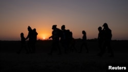 Migrantes de El Salvador y Honduras caminan hacia el muro fronterizo después de cruzar el río Grande, en Penitas, Texas, el 26 de marzo de 2021.