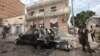 FILE - A Somali soldier stands on guard next to a destroyed car near a popular mall after a car bomb attack in Mogadishu, Somalia, July 30, 2017. The Somalia-based extremist group al-Shabab often carries out deadly bombings in Mogadishu. 