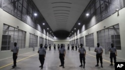 Guardias civiles de la Dirección General de Prisiones apostados afuera de las celdas del Centro de Confinamiento contra el Terrorismo durante una gira de prensa en Tecoluca, El Salvador, el jueves 2 de febrero de 2023.