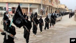 FILE - This undated file image posted on a militant website on Jan. 14, 2014, shows fighters from the al-Qaida linked Islamic State of Iraq and the Levant (ISIL) marching in Raqqa, Syria.