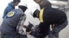 This photo provided by the Syrian Civil Defense White Helmets, which has been authenticated based on its contents and other AP reporting, shows members of the Syrian Civil Defense group helping a wounded man after airstrikes hit eastern Ghouta.