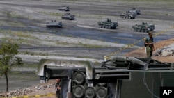 Un sistema lanzamisiles HIMARS de fabricación estadounidense junto a vehículos blindados de transporte de personal después de participar en ejercicio militar conjunto entre EEUU y Filipinas denominado "Balikatan 2016", el 14 de abril de 2016 en Crow Valley, al norte de Manila.