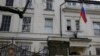 A man works to untangle the national flag flown from the Russian Embassy, after it became entangled on its staff at the embassy in London, March 14, 2018. Britain announced Wednesday it will expel 23 Russian diplomats, the biggest such expulsion since the Cold War.