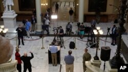 The media separates as Georgia Gov. Brian Kemp speaks about the COVID-19 virus during a news conference at the Georgia state Capitol on April 8, 2020, in Atlanta. 