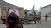 FILE - An Afghan man carries a package distributed by a Turkish humanitarian aid group at a distribution center in Kabul, Afghanistan, Dec. 15, 2021. 