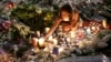 A woman lights candles at a new memorial in a gazebo in a seaside park on the famed Promenade des Anglais in Nice, southern France, July 18, 2016.