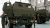 ARCHIVO - Soldados polacos observan un vehículo que transporta uno de los lanzacohetes HIMARS de fabricación estadounidense, en una base aérea en Varsovia, Polonia, el lunes 15 de mayo de 2023. 