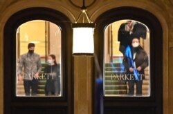Personas abandonan la Ópera de Viena, bajo la supervisión de policías armados, el 2 de noviembre de 2020, luego de un ataque terrorista que dejó dos muertos, incluido un atacante, en el centro de Viena.