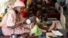 FILE- A mother feeds her malnourished child at a feeding center run by Doctors Without Borders in Maiduguri, Nigeria, Aug. 29, 2016.