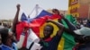 FILE - Protesters hold Russian and Senegalese flags during a Feb. 24, 2024, protest against the postponement of the presidential election scheduled for Feb. 25, in Dakar, Senegal. A commission on Feb. 27 recommended that the delayed election be held in early June.