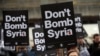 Protesters take part in a small demonstration organized by the Stop the War Coalition against possible military intervention or bombing by western allies in Syria, in London, April 13, 2018. 