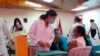 Una enfermera habla con una mujer que está a punto de ser inoculada con la vacuna AstraZeneca COVID-19 en el hospital Berta Calderón en Managua, Nicaragua, el jueves 8 de abril de 2021.