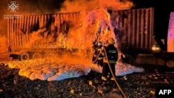 Los bomberos trabajan para extinguir un incendio en la infraestructura portuaria en el río Danubio, en la región de Odesa, el 6 de octubre de 2023, en medio de la invasión rusa en Ucrania. (Servicio de Emergencia de Ucrania vía AFP)