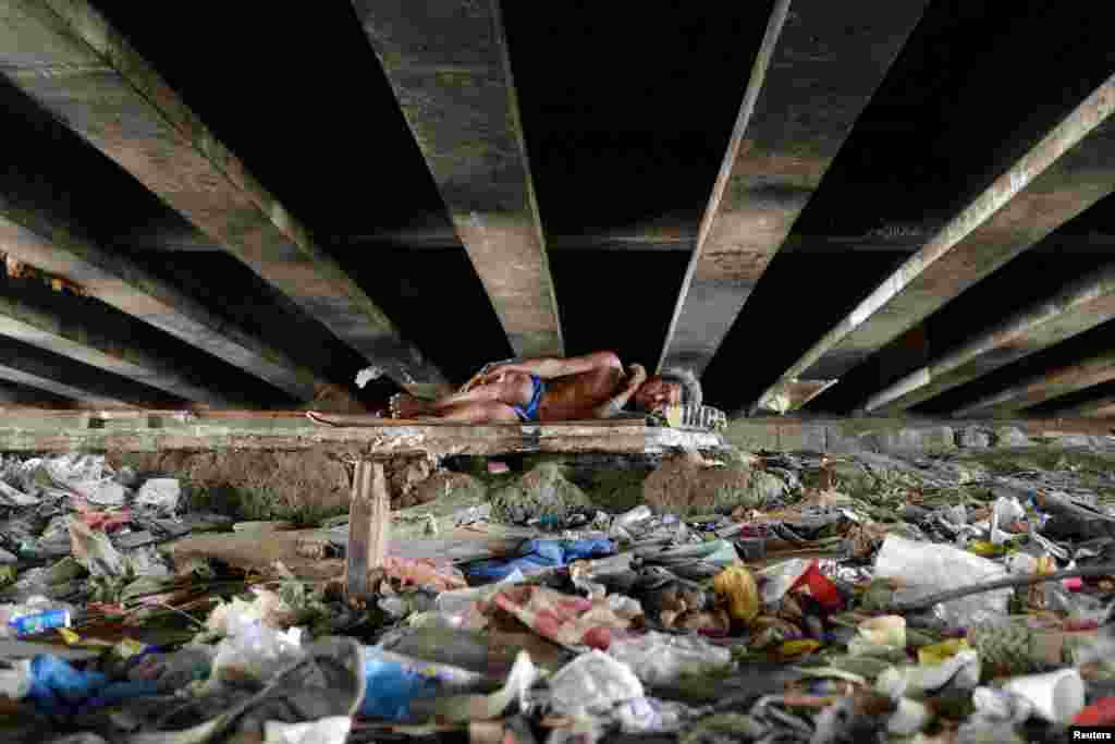Seorang pria tidur di bawah jembatan di kota Paranaque, Metro Manila, Filipina.