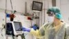 The director of the epidemics service Dr Karina Glick checking a medical ventilator control panel at a ward, while wearing protective clothing. 