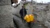 FILE - An Afghan man uses a wheelbarrow to move containers of water in Kabul, Feb. 12, 2018.
