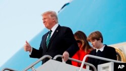 El presidente Donald Trump con la primera dama Melania Trump y su hijo Barron Trump, cuando llegan al aeropuerto internacional de Palm Beach en West Palm Beach, Florida, 2017.