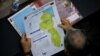 Un parlamentario venezolano revisa un mapa del territorio en disputa entre su país y Guyana desde el siglo XIX, conocido como El Esequibo, el 6 de diciembre de 2023, 