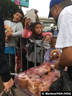 Niños migrantes compran el desayuno del lado mexicano. [A. Martínez/VOA].