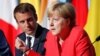 FILE - French President Emmanuel Macron and German Chancellor Angela Merkel attend a news conference following talks on European Union integration, defense and migration at the Elysee Palace in Paris, Aug. 28, 2017.